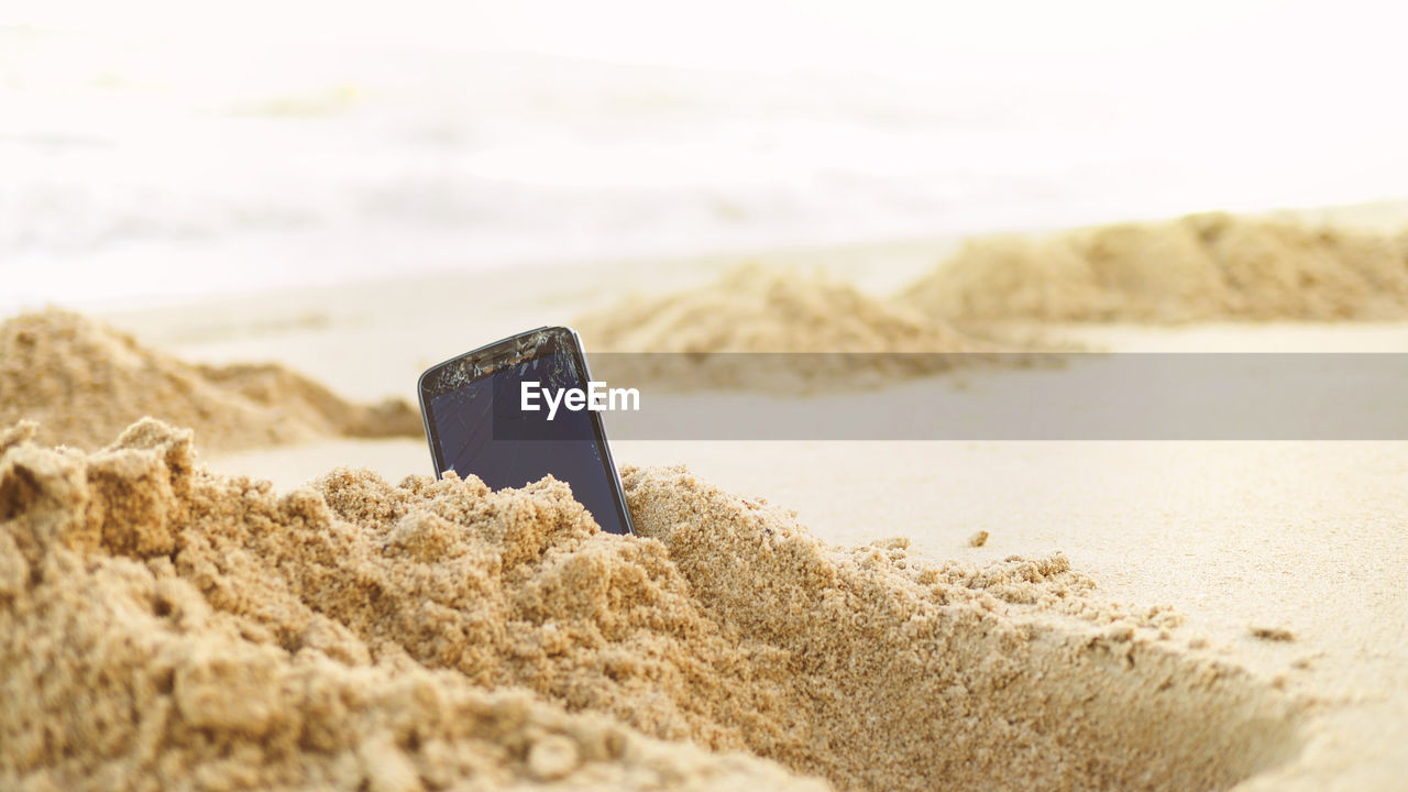 A smartphone in the sand on a beach , copy space for you text