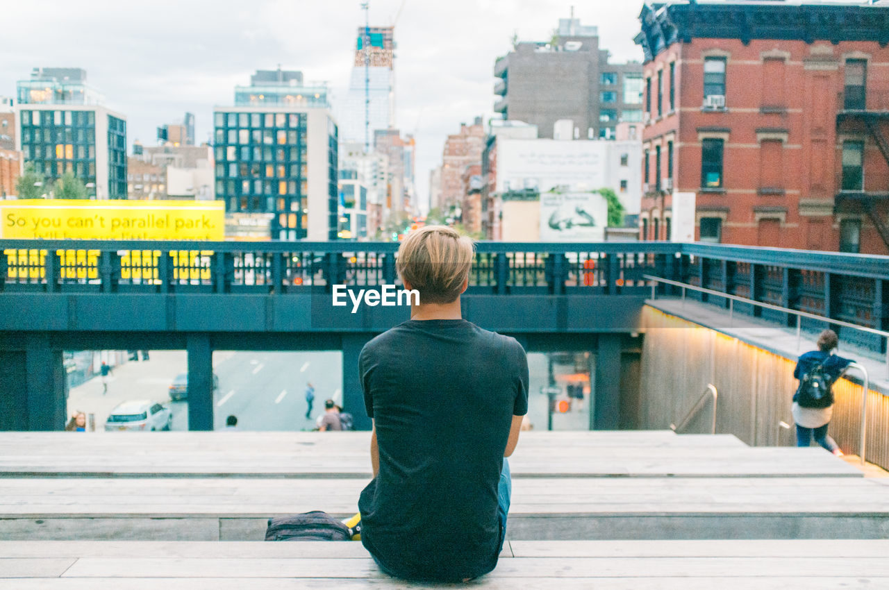 Rear view of man sitting in city