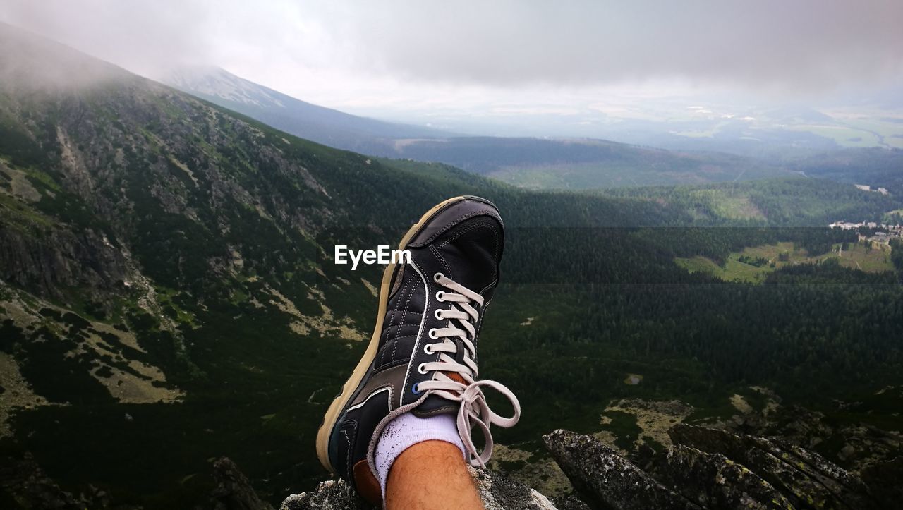 Low section of man standing on mountain road