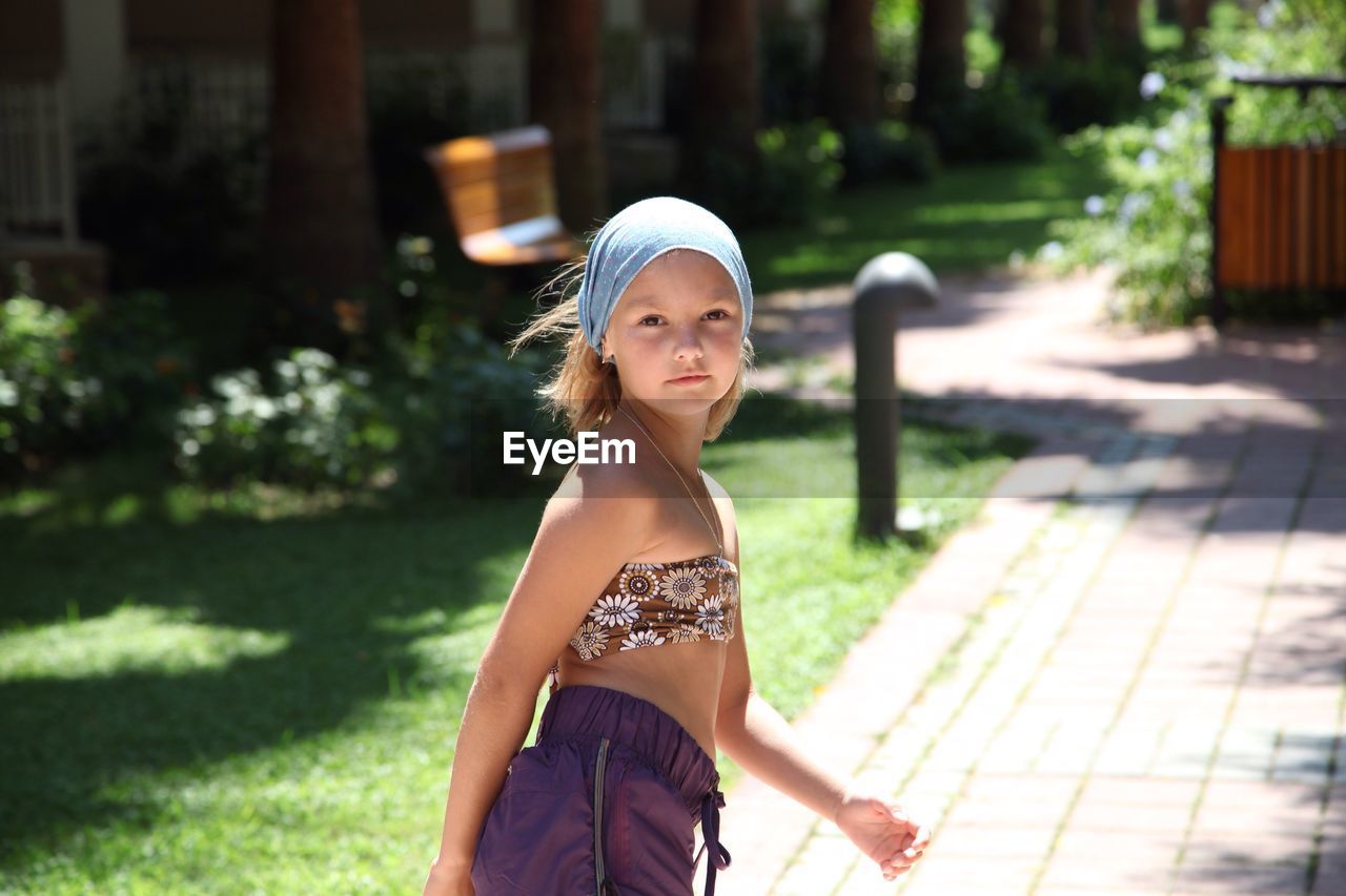 Portrait of girl standing on pavement