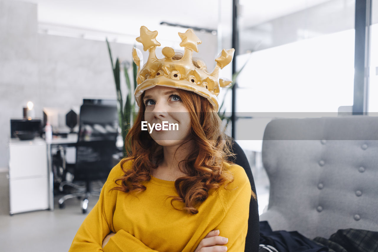 Businesswoman in office wearing a crown