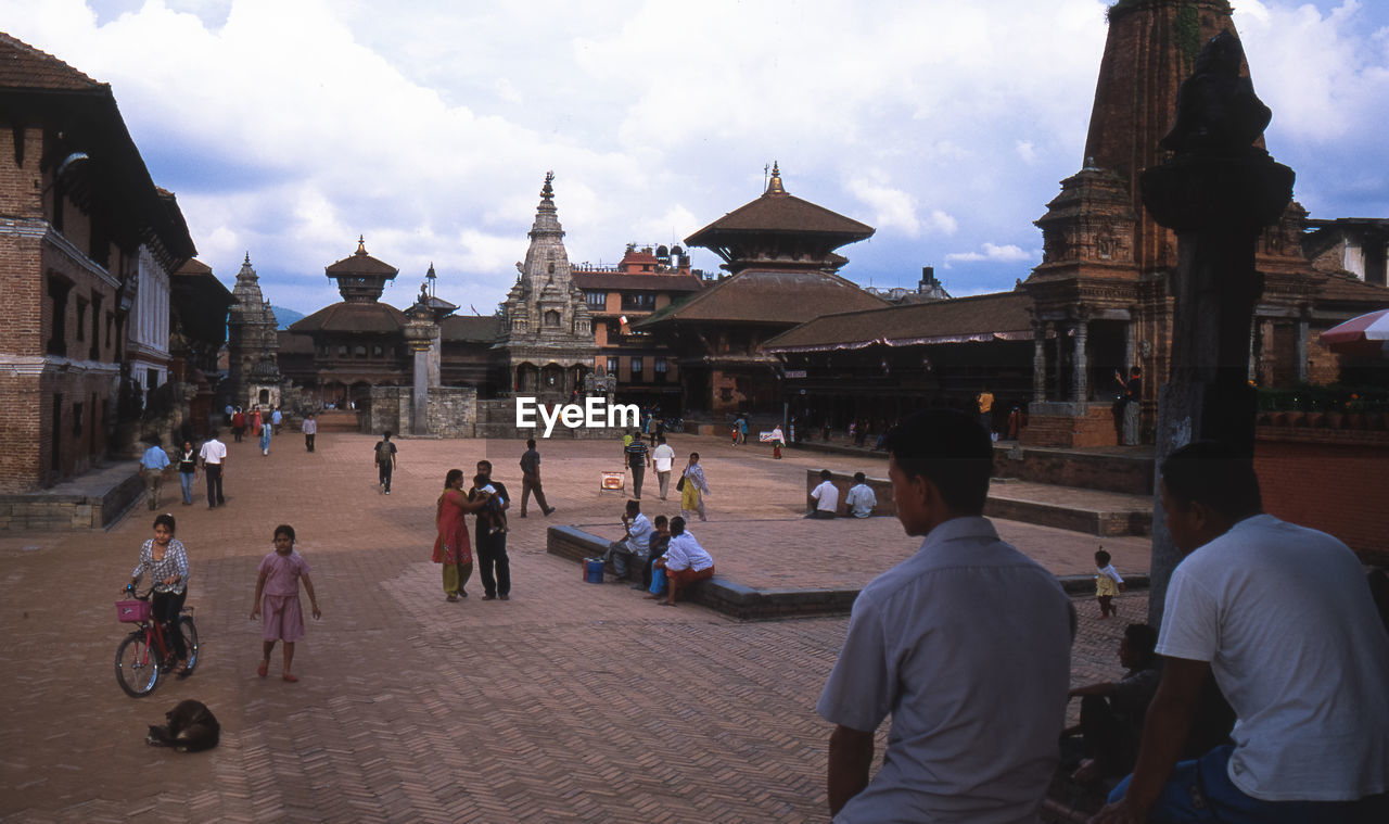 TOURISTS IN FRONT OF HISTORIC BUILDING AGAINST SKY