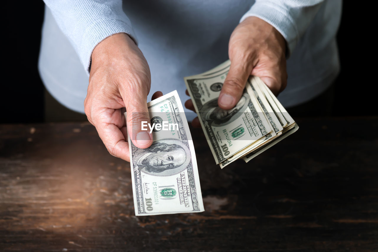 Midsection of man giving money at table