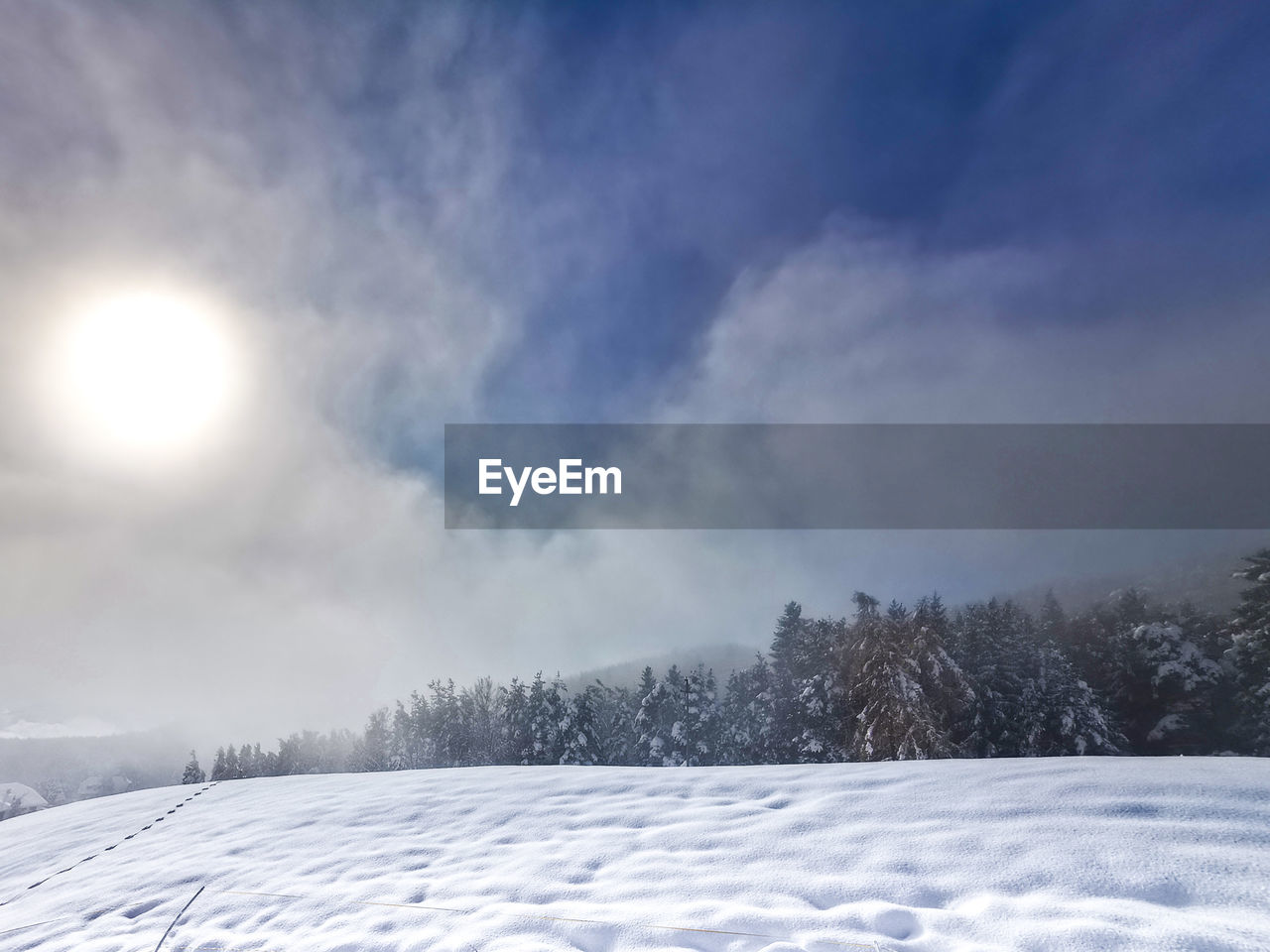 Snow covered landscape against sky