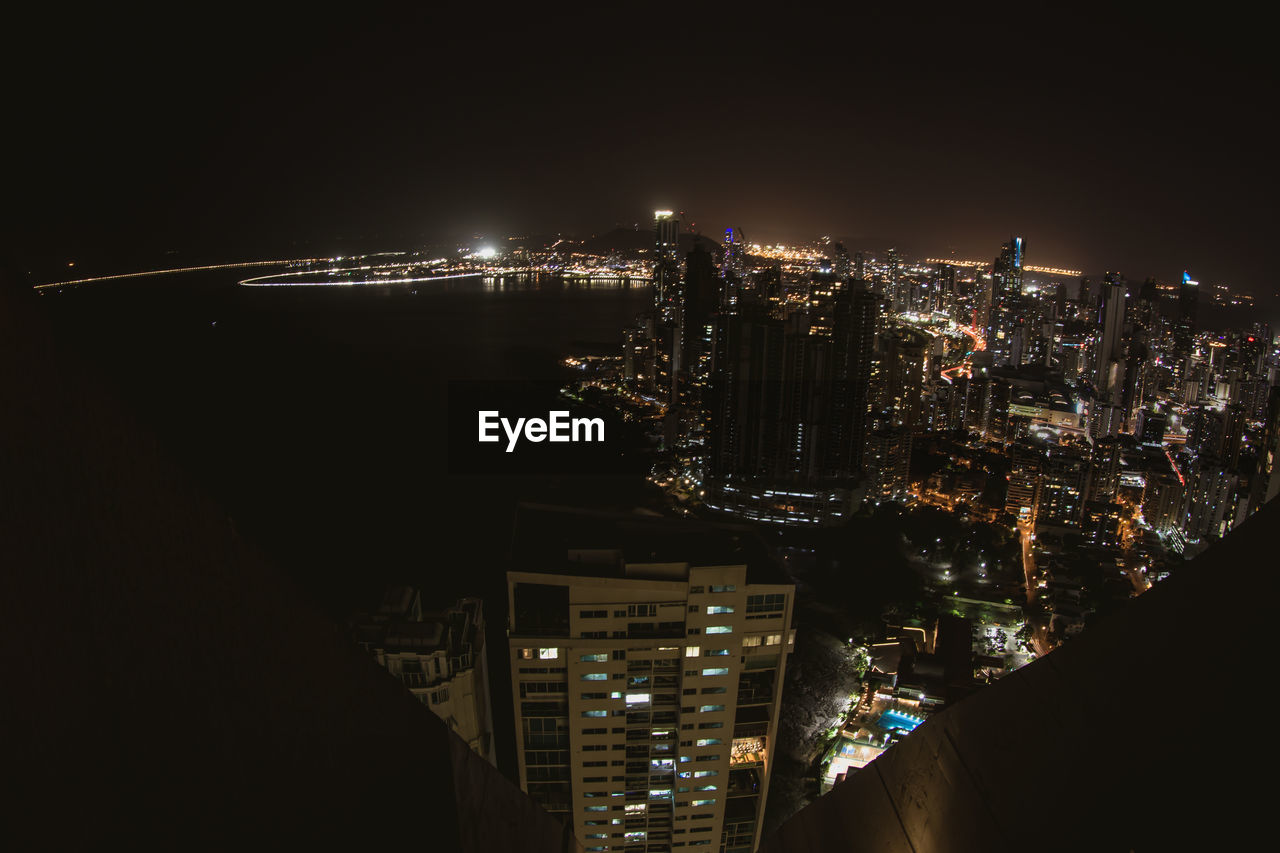 HIGH ANGLE VIEW OF ILLUMINATED BUILDINGS AT NIGHT