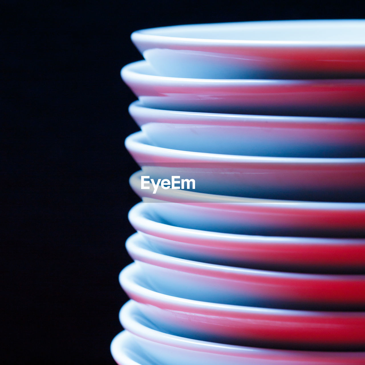 Close-up of plates stacked against black background