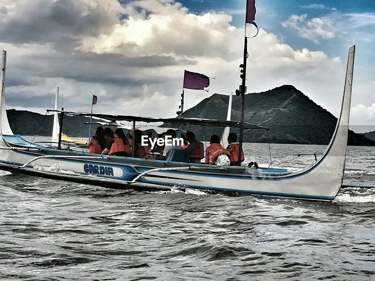 PEOPLE ON BOAT SAILING ON SEA AGAINST SKY