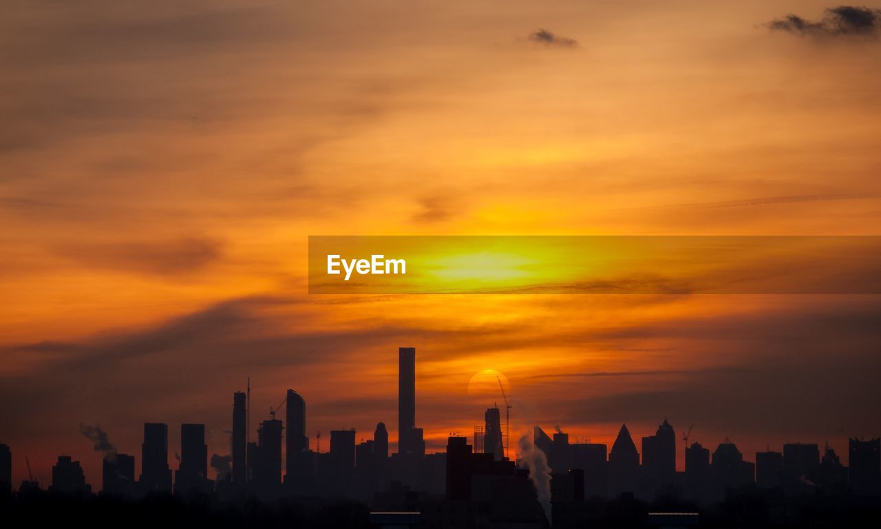 SCENIC VIEW OF SILHOUETTE BUILDINGS AGAINST SKY DURING SUNSET