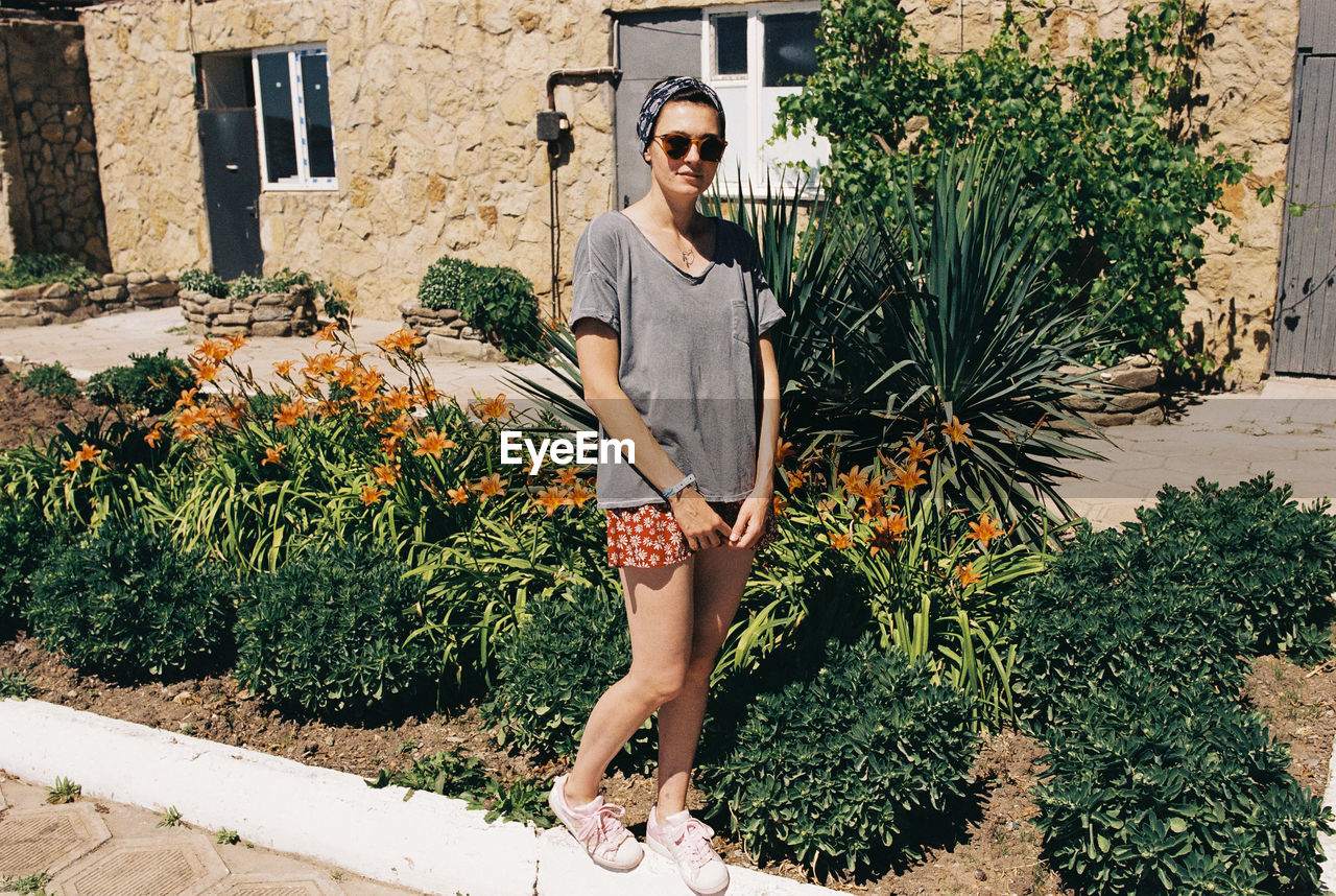 Portrait of woman standing against plants