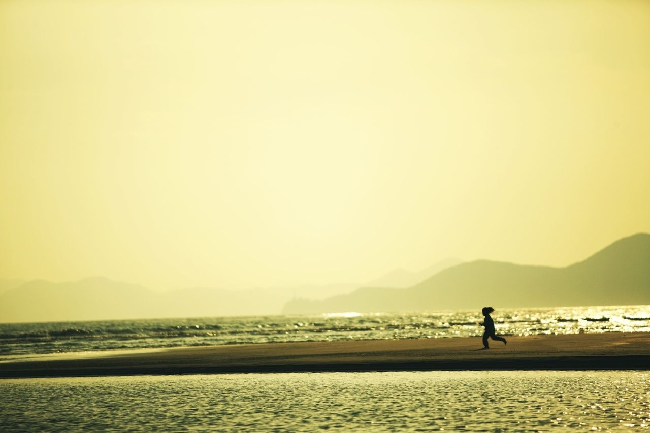 Silhouette girl running on beach