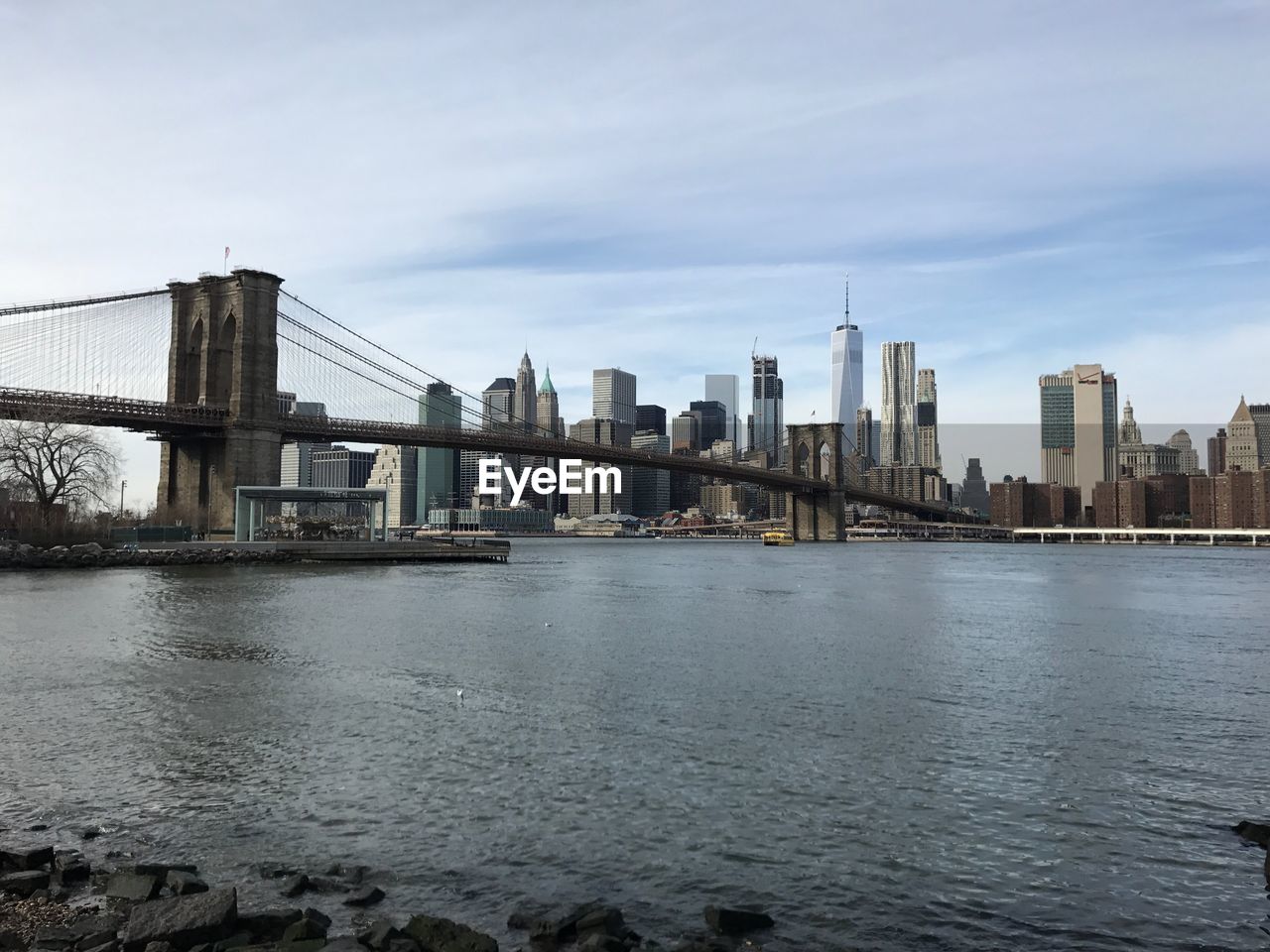 Bridge over river in city against sky