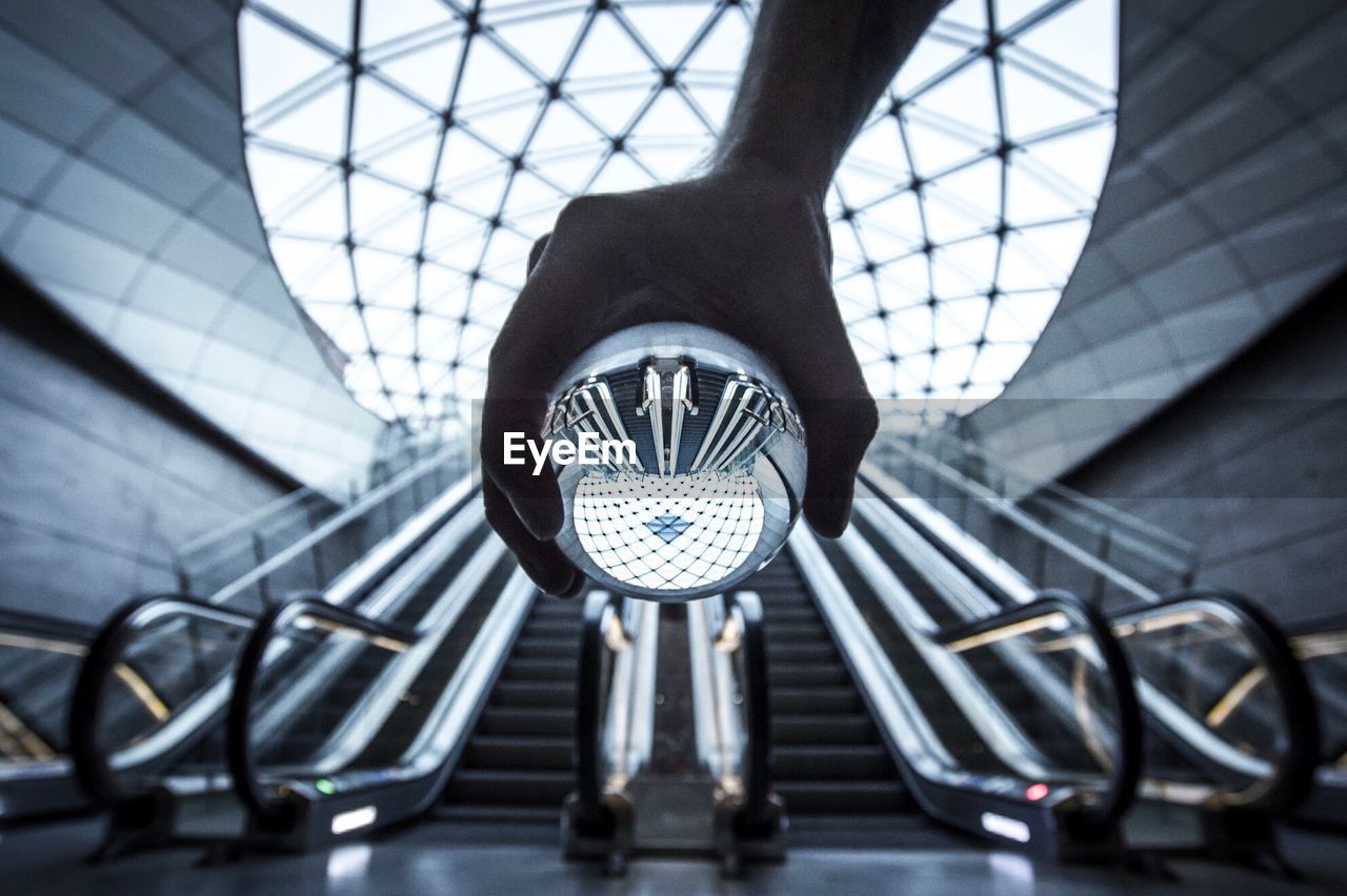 Hand holding a crystal ball reflecting futuristic architecture