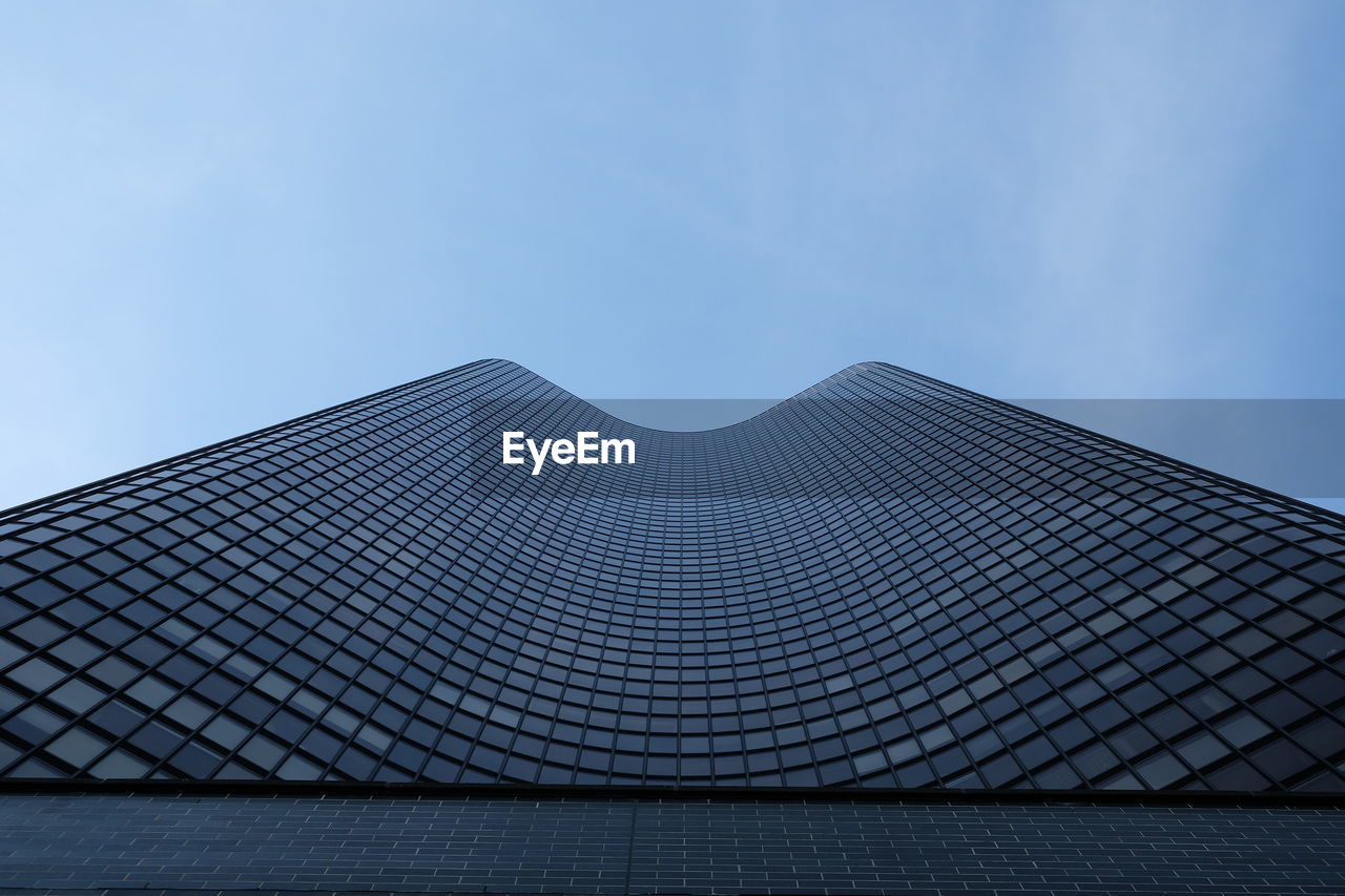 Low angle view of modern building against blue sky