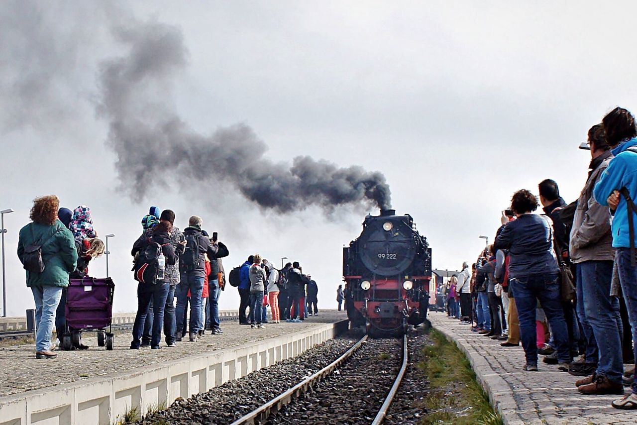 Steam train on tracks amidst people