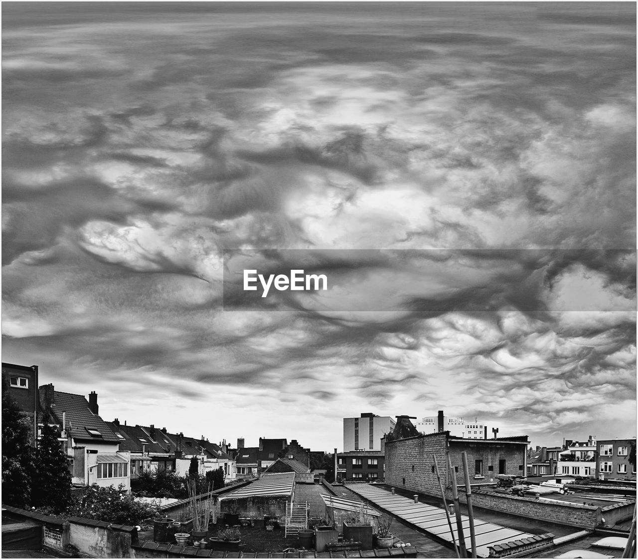 VIEW OF CITYSCAPE AGAINST CLOUDY SKY