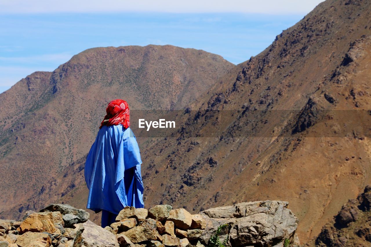 Rear view of man looking at atlas mountain against sky in morocco 