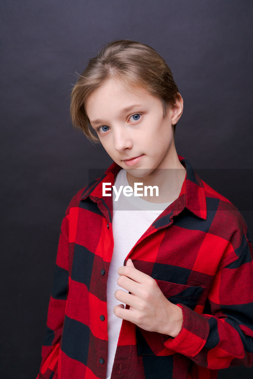 Close-up headshot of confident concentrated young man in plaid shirt looking