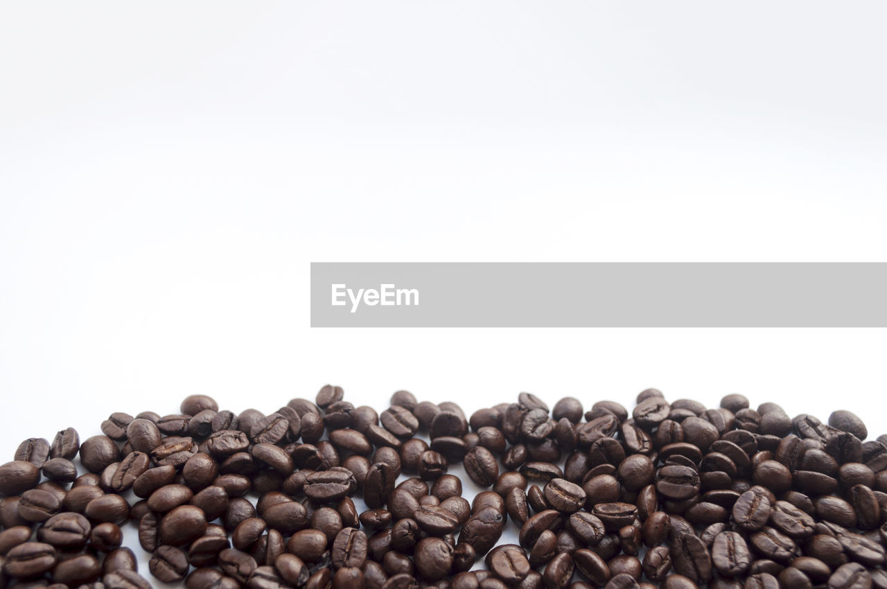 Close-up of roasted coffee beans on white background