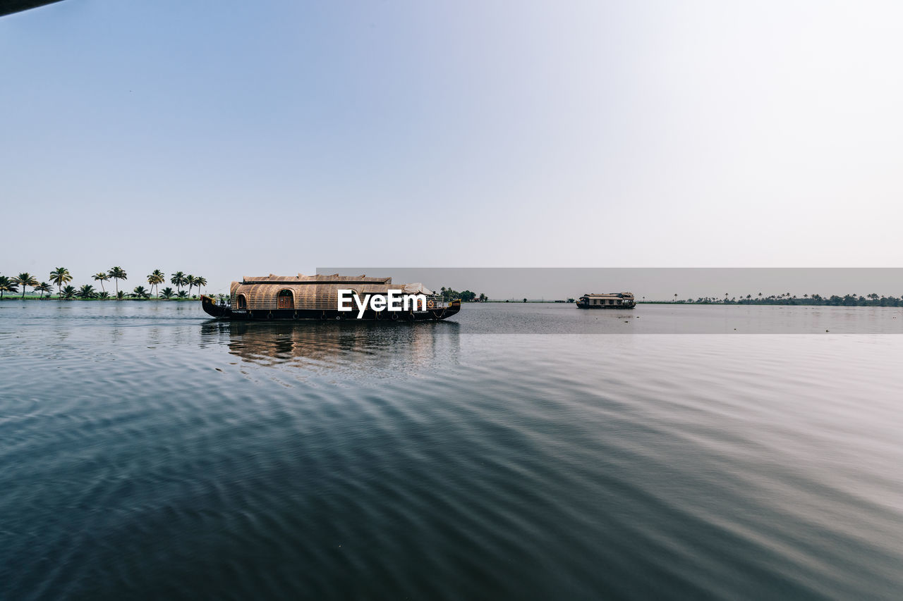 Houseboat in lake against clear sky