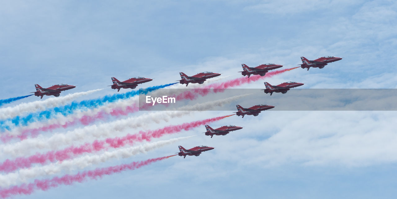 LOW ANGLE VIEW OF AIRSHOW IN MID-AIR AGAINST SKY