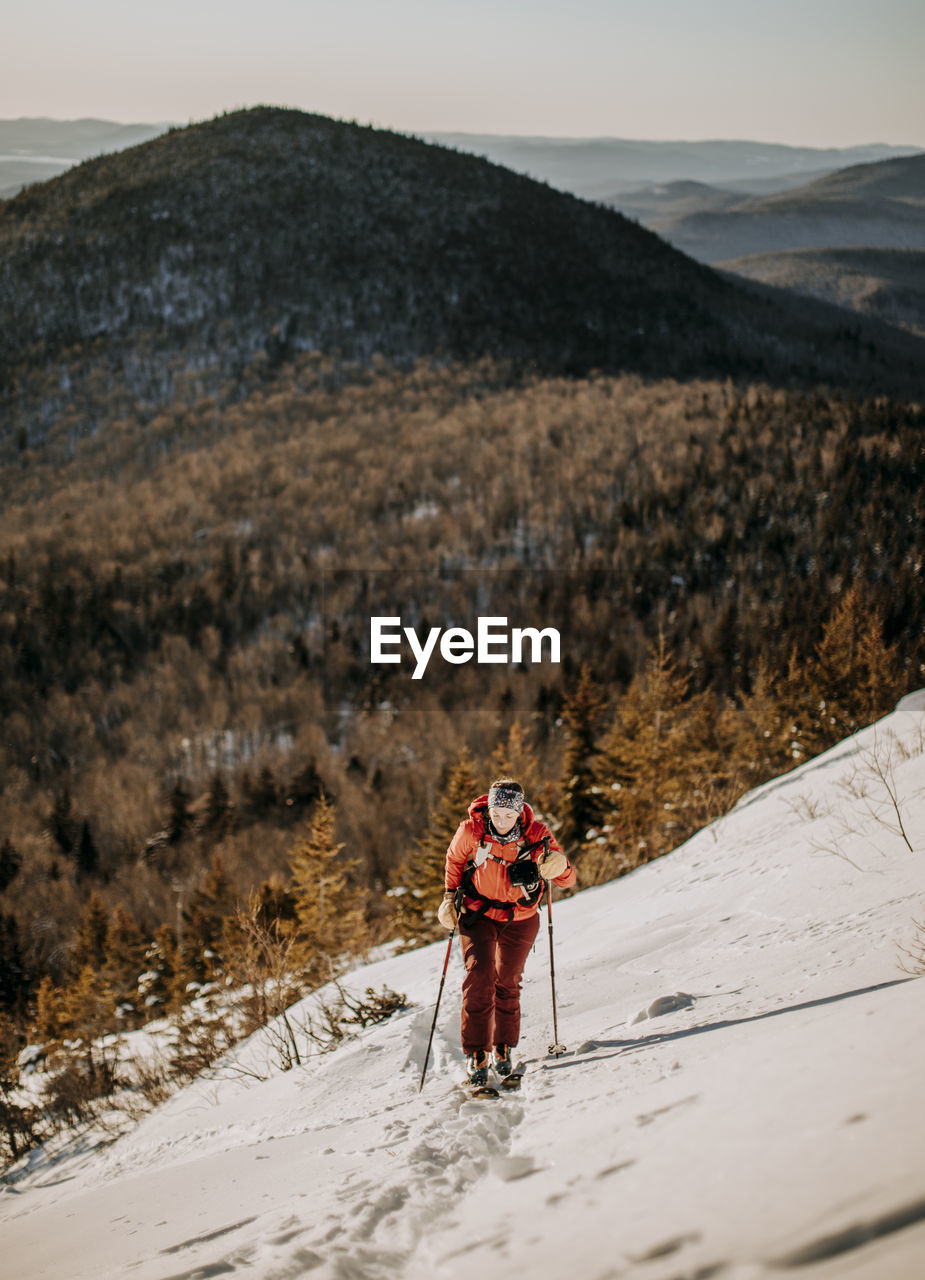 A woman backcountry skis up baldface mountain, new hampshire.