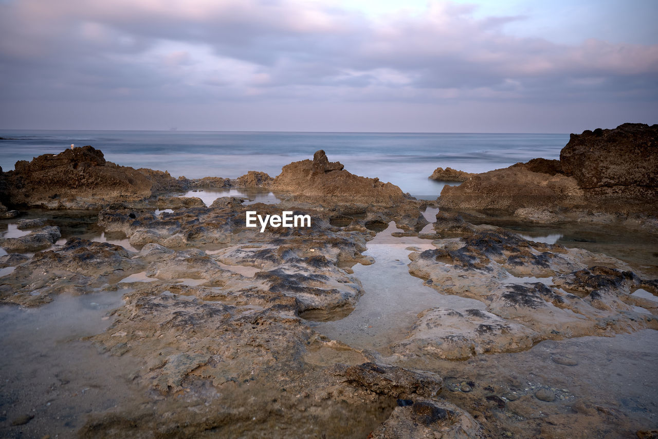 Rocks on beach against sky