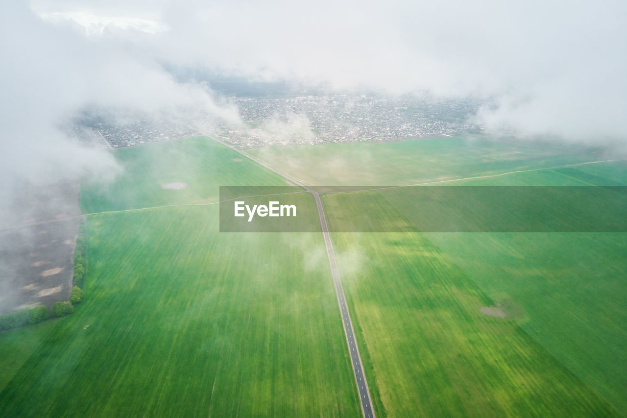 Flight through the clouds. aerial view of green field with fluffy clouds. nature landscape