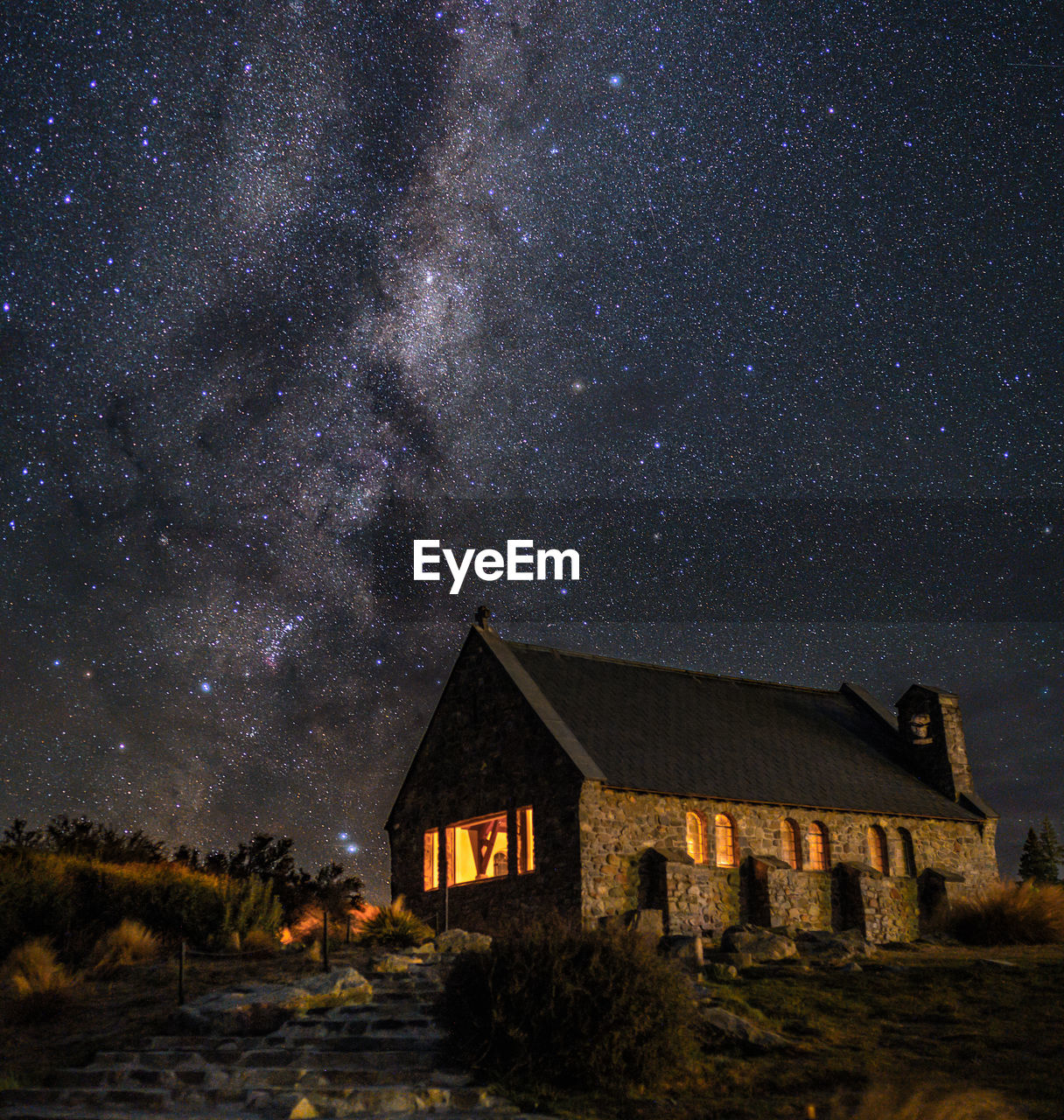 HOUSE ON ILLUMINATED BUILDING AGAINST SKY