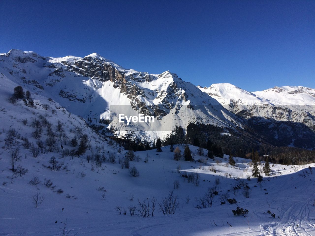 Scenic view of snowcapped mountains against clear blue sky