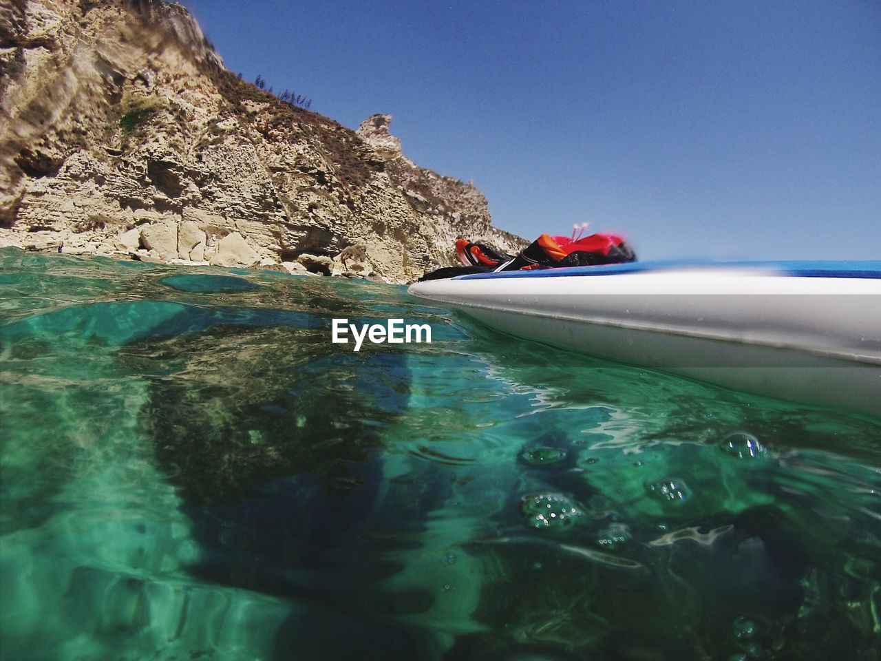 Scenic view of rocks in sea against clear sky