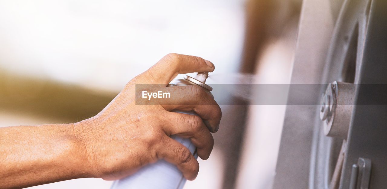 CLOSE-UP OF MAN HOLDING CIGARETTE
