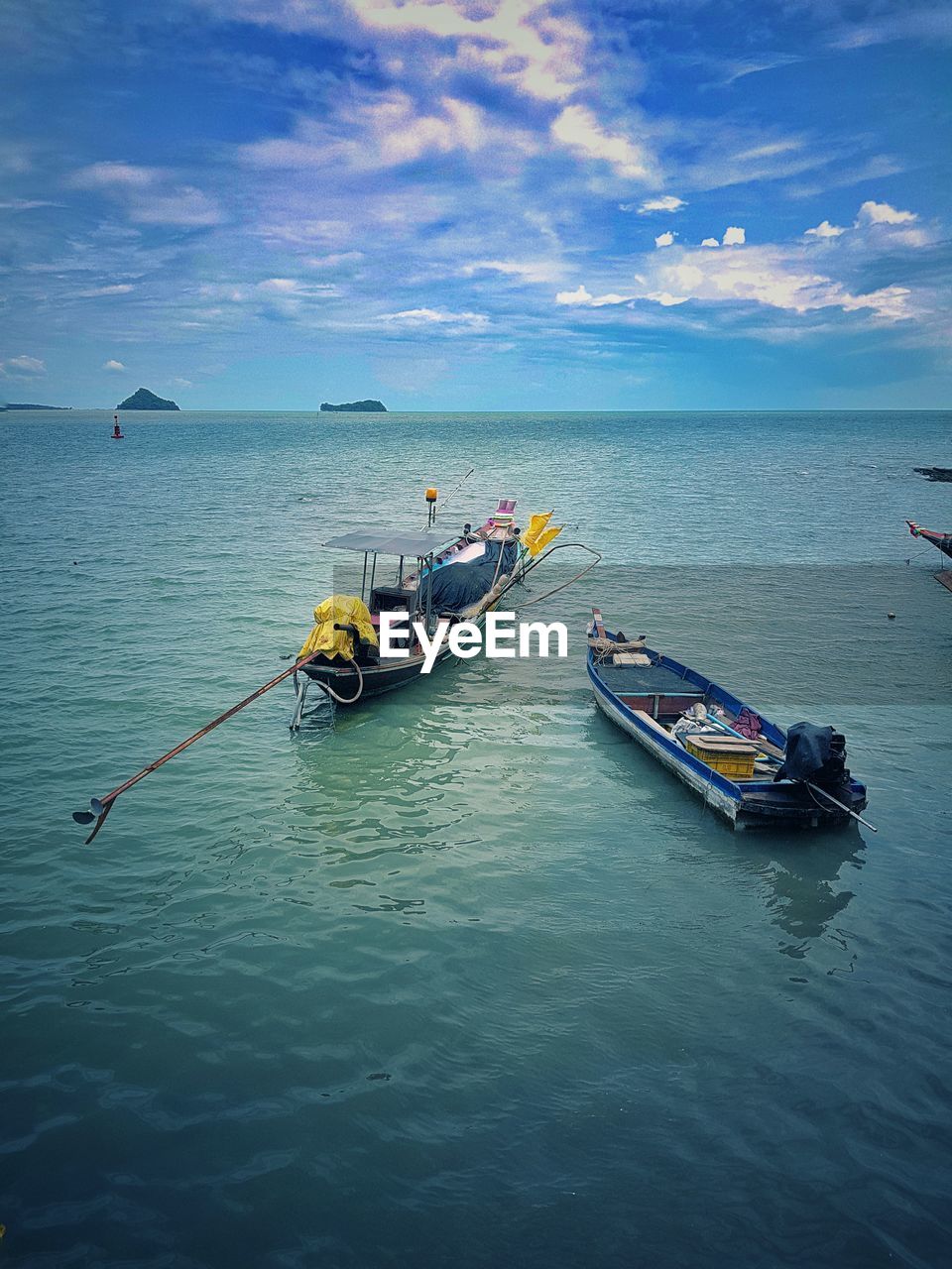 Boats moored in sea against sky