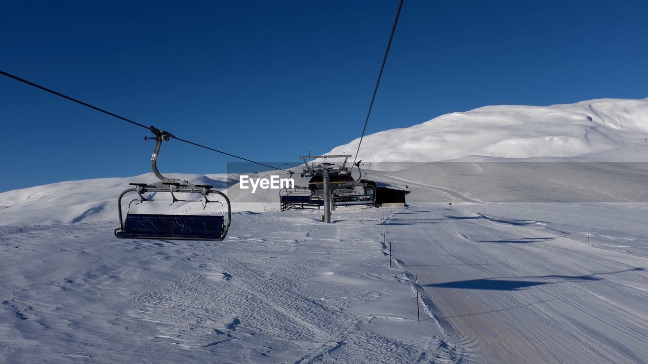 OVERHEAD CABLE CAR OVER SNOW COVERED MOUNTAIN