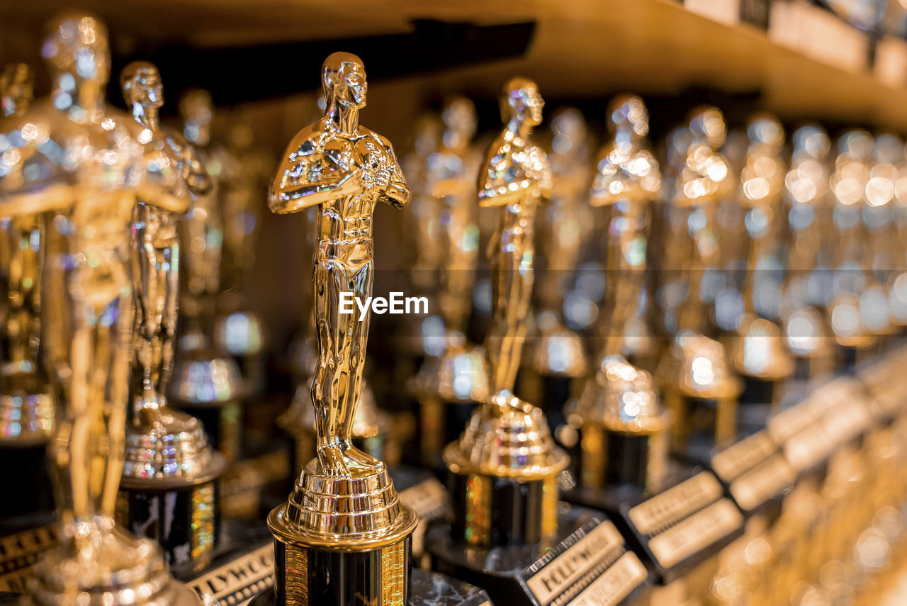 Hollywood golden oscar academy trophies arranged on shelf for sale in shop