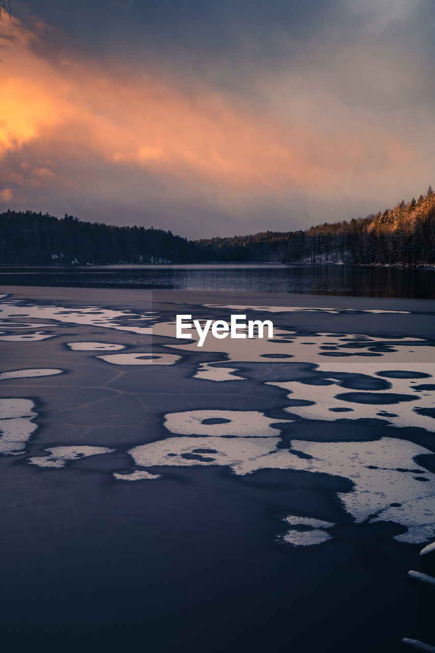 FROZEN LAKE AGAINST SKY DURING SUNSET