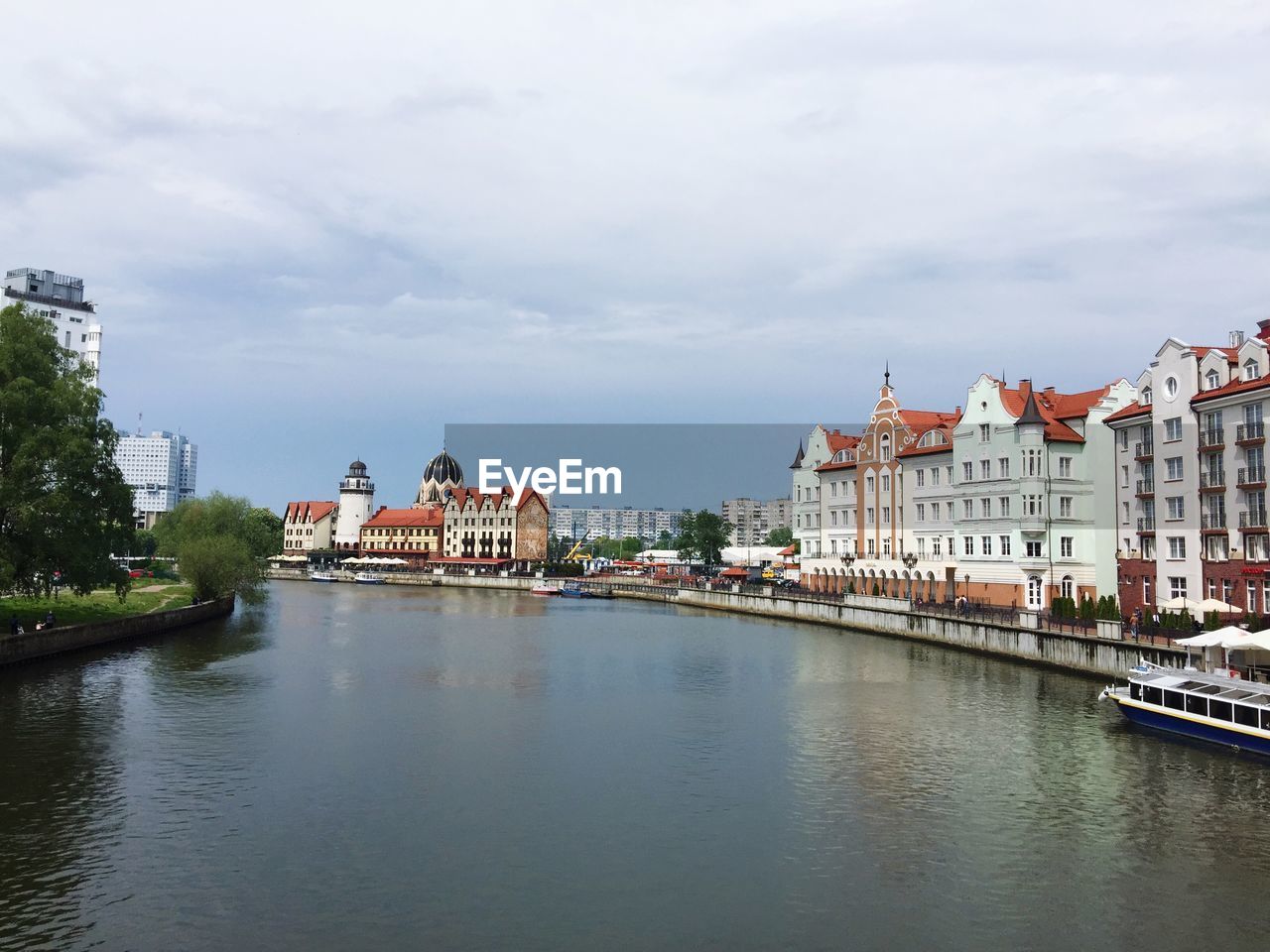 BUILDINGS BY RIVER AGAINST SKY IN CITY