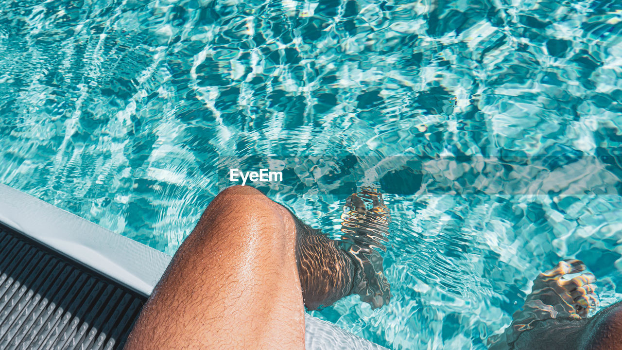 Low section of men in swimming pool