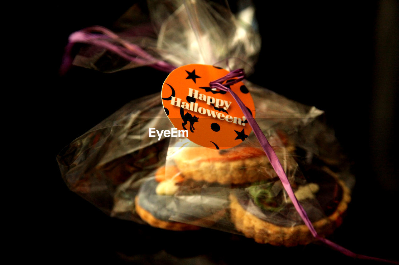 Close-up of cupcakes in plastic with text on glass table