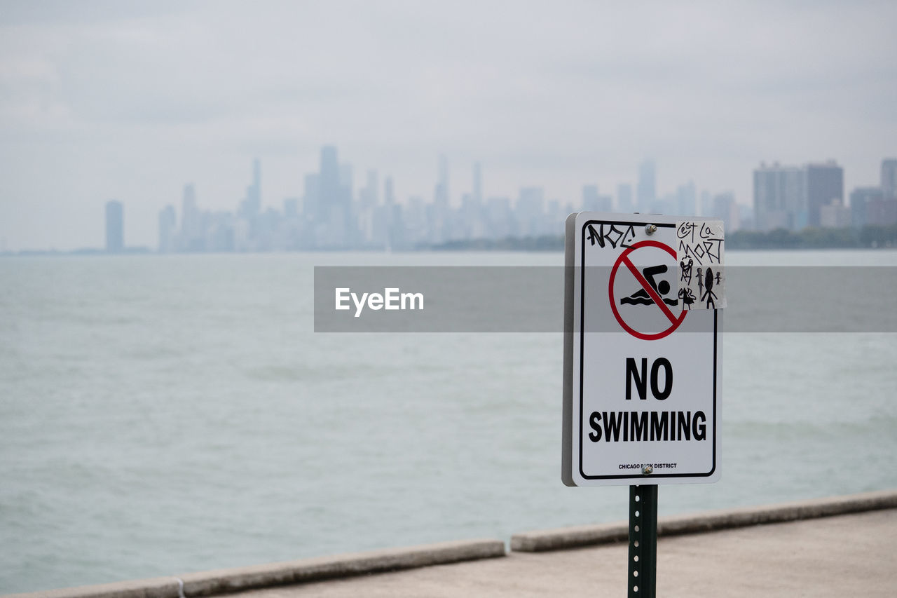 close-up of road sign against sea