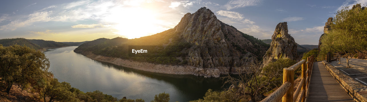 Panoramic view of lake and mountains against sky during sunset