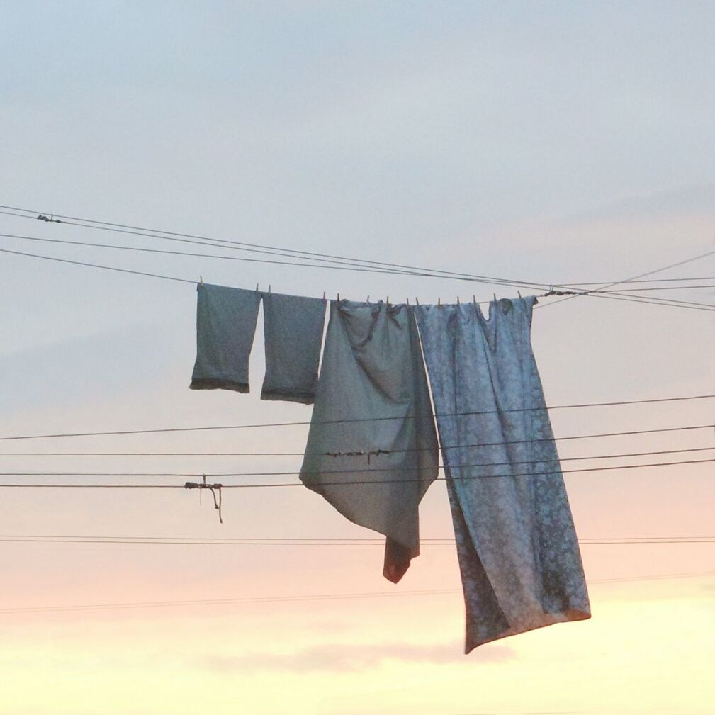 LOW ANGLE VIEW OF CLOTHES DRYING HANGING ON CLOTHESLINE