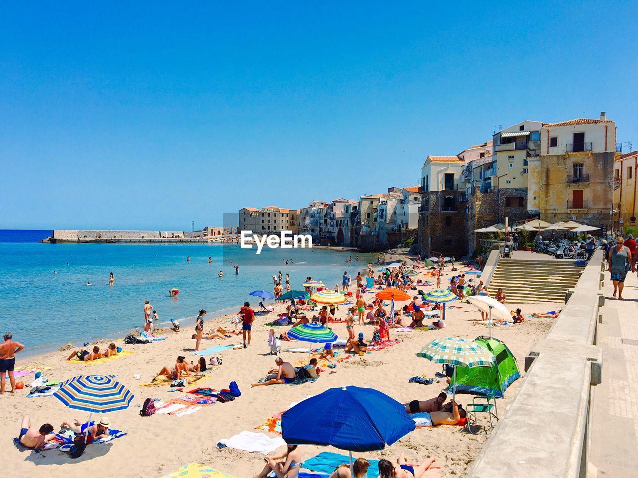 People on beach against clear sky