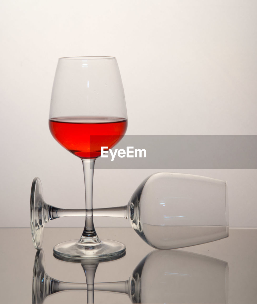 Close-up of wineglasses on table against gray background