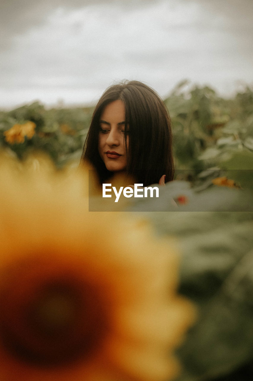 Young woman standing at sunflower farm