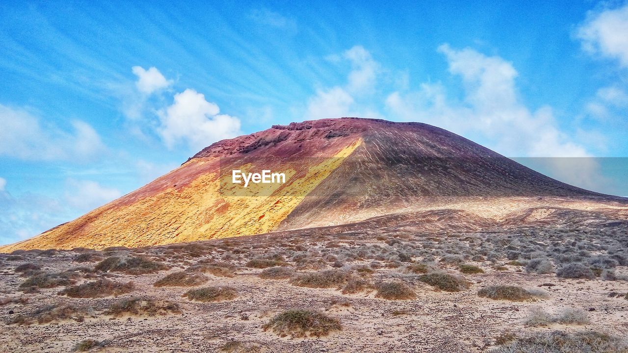 View of volcanic landscape against cloudy sky