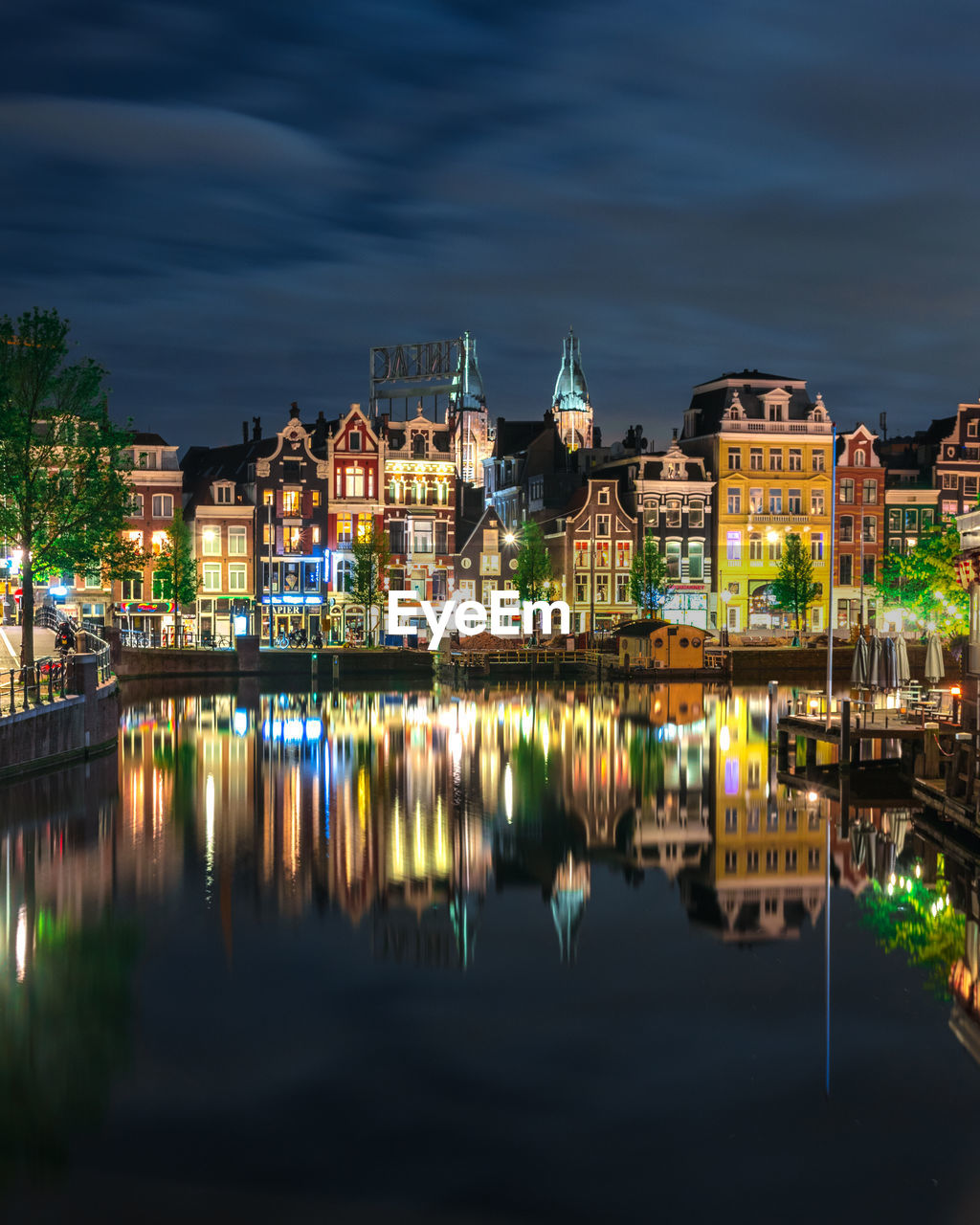 A very calm night in amsterdam with smooth reflections of the buildings on the water.