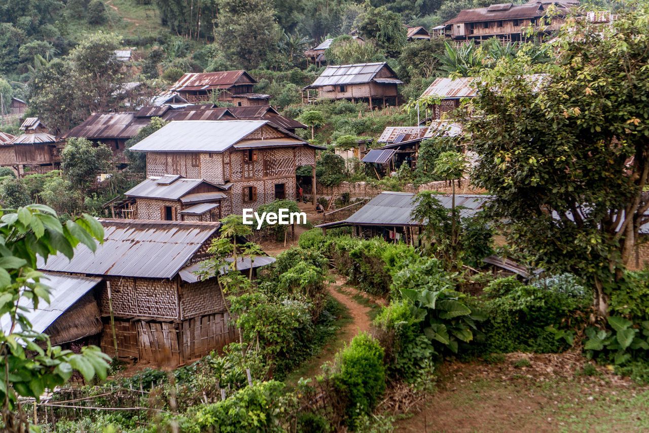 HOUSES IN VILLAGE AMIDST BUILDINGS IN CITY
