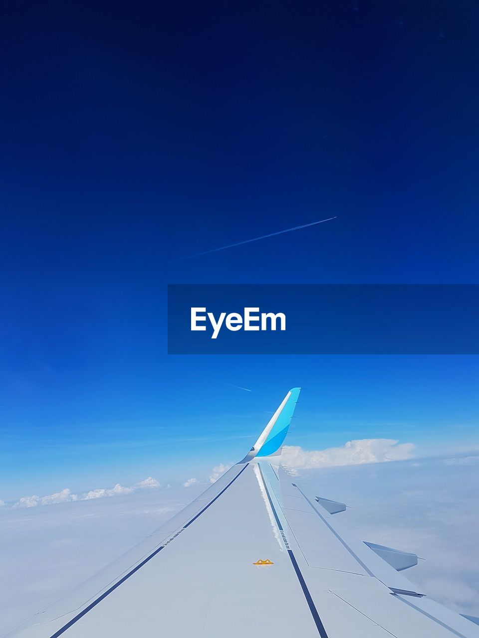 AIRPLANE FLYING AGAINST BLUE SKY