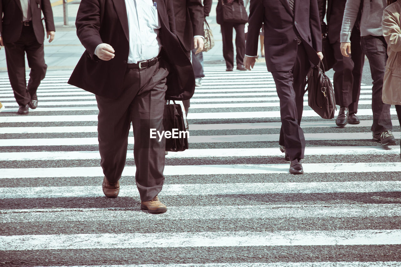 Low section of people walking on street