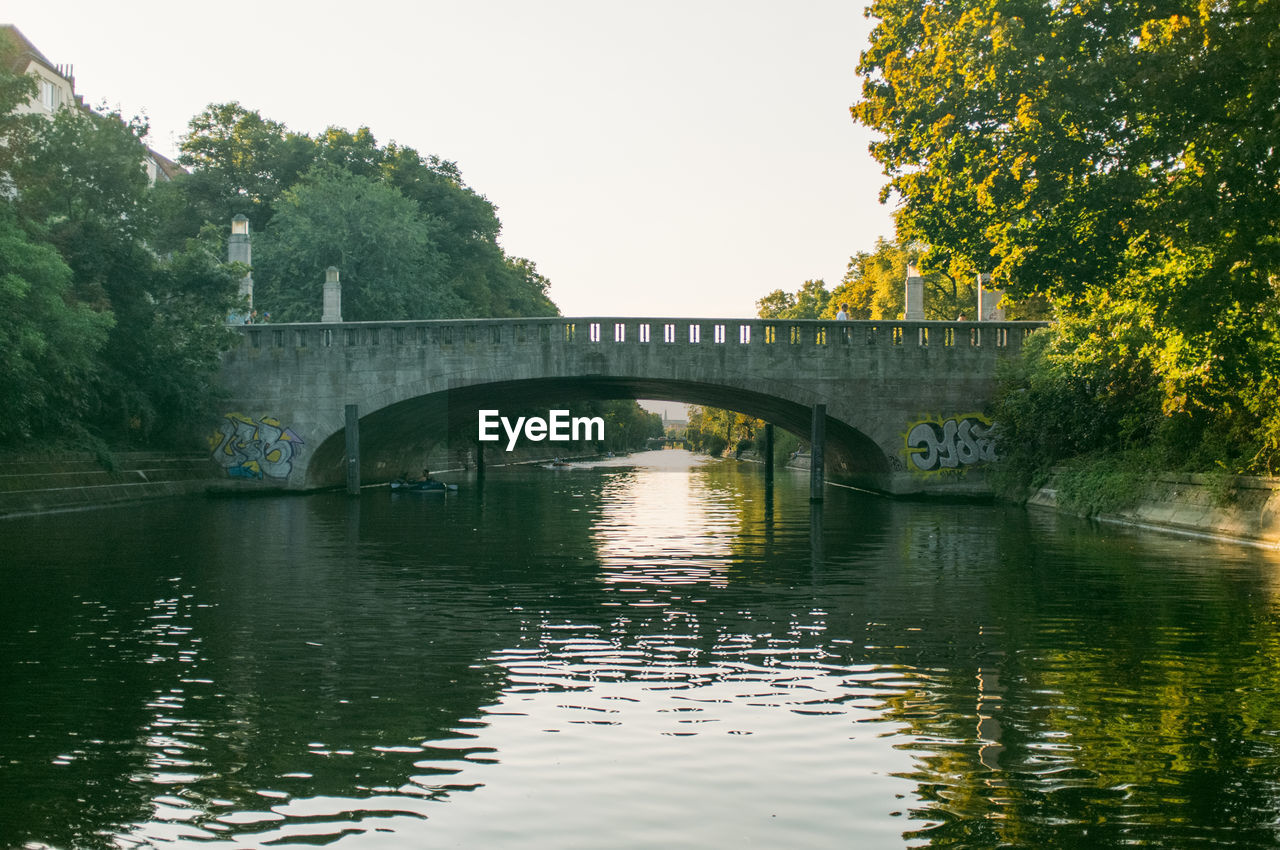 Arch bridge over river against sky